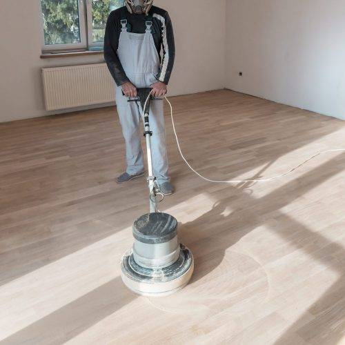 Man (master ) clean the parquet with special polishing machine